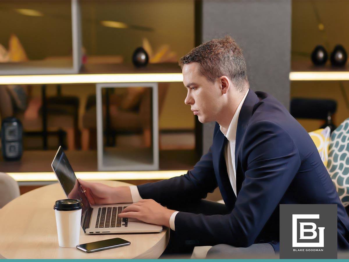 Man working on a laptop in a modern office, researching bankruptcy solutions